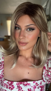 Roxie wearing HARLOW by NORIKO in MELTED-MARSHMALLOW | Subtly Warm Dark Sandy Blonde Blend with Medium Brown Roots and Light Ash Blonde Tips and Highlights