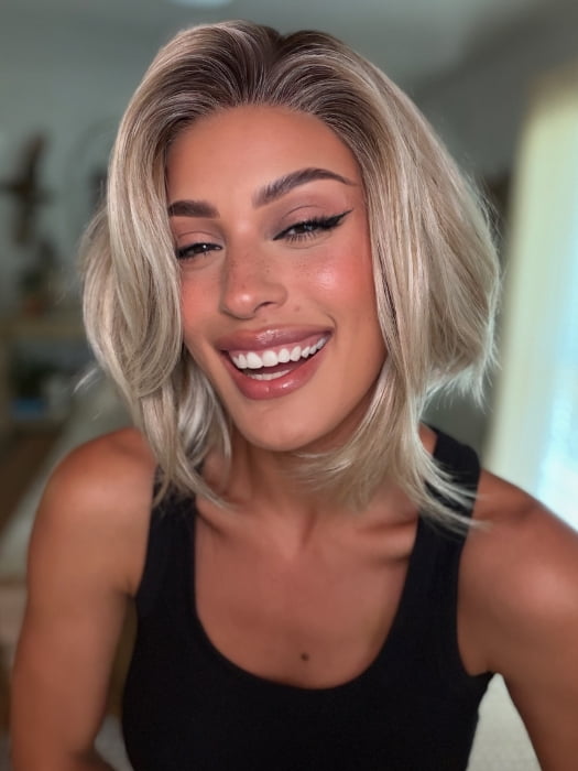 Roxie wearing MIRA by AMORE in SEA SALT BLOND R | A perfect mixture of cool, icy-blond and warm-dark blond. The rich brown root tone enhances the modern appearance.
