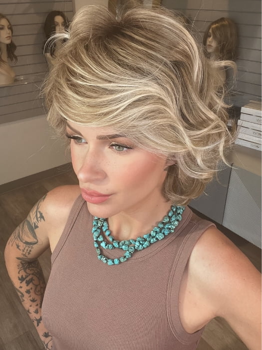 Madeline wearing MONROE by BELLETRESS in BUTTERCAKE BLONDE-R | A neutral-warm blonde blend featuring light brown, ash, and lightest blonde tones with natural-looking darker roots for added depth and realism.
