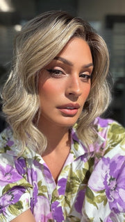 Roxie is wearing VERONICA by BELLETRESS in SPARKLING CHAMPAGNE BLONDE R | A radiant blend of champagne blonde with soft golden and beige tones, grounded by natural-looking roots in ash brown and dark blonde.