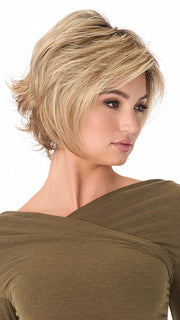 Model is wearing ANGIE by ENVY in color SPARKLING-CHAMPAGNE | Medium Brown roots with overall Strawberry Blonde base and soft Golden Blonde highlights