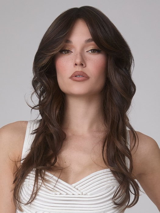 Model is wearing MEDIUM WAVY TP MONO by AMORE in color SPICED MOCHA R | A dark-brown base with perfectly placed warm-medium brown and medium reddish-brown highlights. The root tone adds a natural shadowed effect.