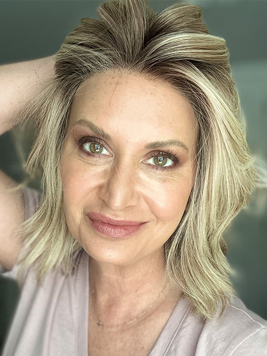 Emily H. @she_sheds_more wearing CYRUS by BELLE TRESS in color BUTTERCAKE BLONDE-R | A neutral-warm blonde blend featuring light brown, ash, and lightest blonde tones with natural-looking darker roots for added depth and realism.