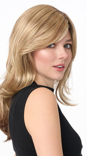 Model is wearing JOY by ENVY in color SPARKLING-CHAMPAGNE | Medium Brown roots with overall Strawberry Blonde base and soft Golden Blonde highlights