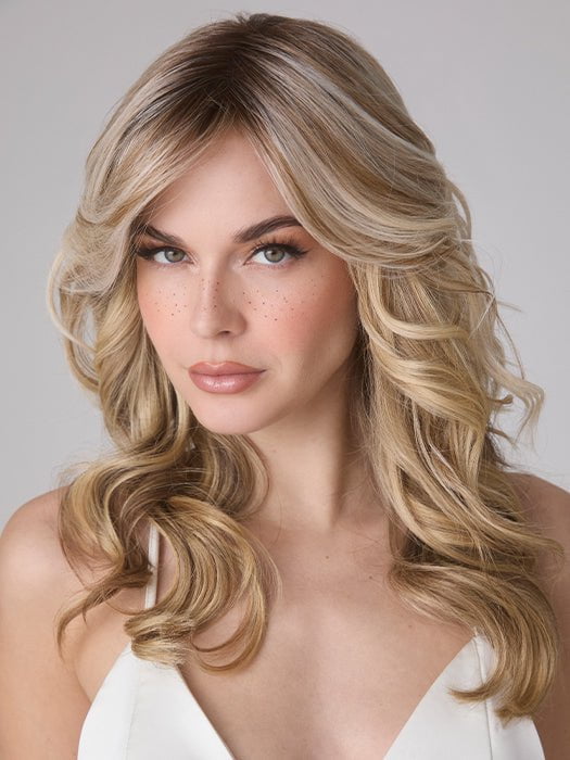 Model is wearing MEDIUM WAVY TP MONO by AMORE in color SEA SALT BLOND R | A perfect mixture of cool, icy-blond and warm-dark blond. The rich brown root tone enhances the modern appearance. 