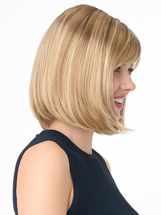 Model is wearing PAIGE PETITE by ENVY in color SPARKLING CHAMPAGNE | Medium Brown roots with overall Strawberry Blonde base and soft Golden Blonde highlights