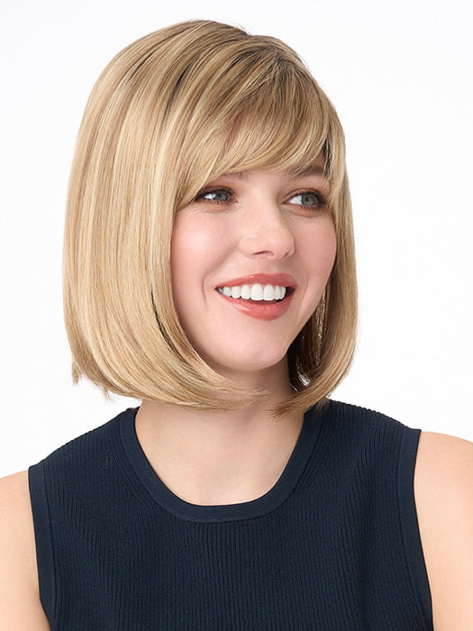 Model is wearing PAIGE PETITE by ENVY in color SPARKLING CHAMPAGNE | Medium Brown roots with overall Strawberry Blonde base and soft Golden Blonde highlights