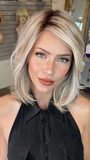 Madeline wearing PARK AVE by BELLE TRESS in color MILKSHAKE BLONDE R | A mixture of Light Sandy Brown, Highlighted with Light Ash Blonde with a Hint of Light Platinum Blonde with a Medium Root Color