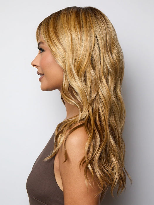 Model is wearing POSH WAVEZ in Bronzed Honey-R  | A perfect blend of rich, warm golden blond and medium chocolate brown tones, complemented by a dark chocolate root that adds a luxurious, dimensional effect.