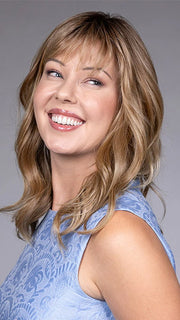 Model is wearing SWIFT in color CARAMEL TOFFEE BLONDE R | Caramel Toffee is a warm, dimensional shade blending medium brown with golden blonde and caramel highlights. Softly rooted for a natural, sun-kissed finish.