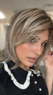 Model is wearing TIMELESS CHARM by RAQUEL WELCH in color RL12/22SS SHADED CAPPUCCINO | Light Golden Brown Evenly Blended with Cool Platinum Blonde Highlights and Dark Roots