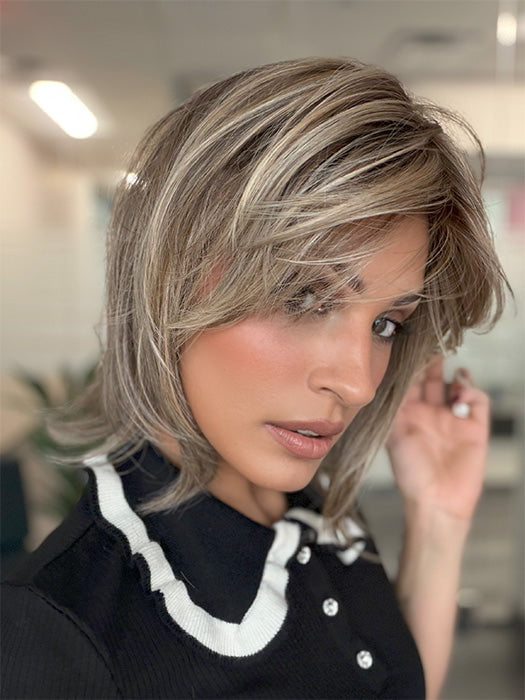 Model is wearing TIMELESS CHARM by RAQUEL WELCH in color RL12/22SS SHADED CAPPUCCINO | Light Golden Brown Evenly Blended with Cool Platinum Blonde Highlights and Dark Roots