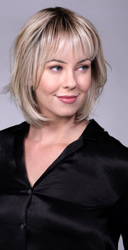 Model is wearing TRIBECA By BELLETRESS in CRUSHED-ALMOND-BLONDE-R | A Soft Neutral Light Blonde with a Light and Medium Blended Root Color