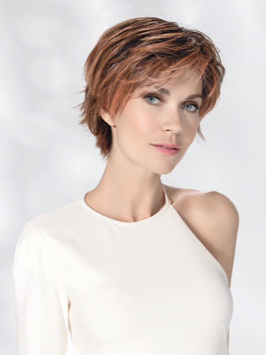 Model is wearing AVENUE SOFT by ELLEN WILLE in color ROSEWOOD LIGHTED | Medium Brown, Caramel, and Rose Gold blend with Highlights Throughout and Concentrated in the Front with Shaded Roots