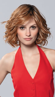 Model is wearing ELLE MONO by ELLEN WILLE in color PUMPKIN ROOTED | Dark Strawberry Blonde with Light Reddish Auburn and Copper Red Blend With Shaded Roots