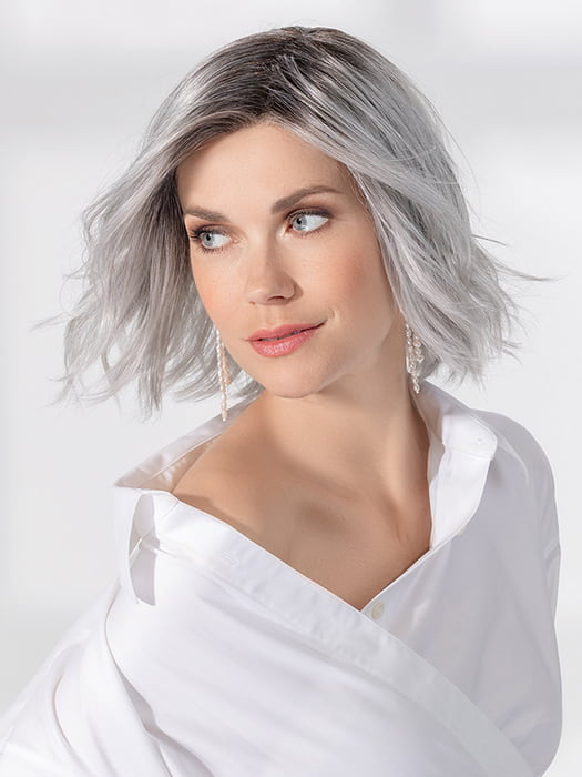 Model is wearing ESPRIT SOFT SMALL by ELLEN WILLE in color METALLIC GREY ROOTED 60.51 |  Pearl White, Darkest/Lightest Brown with Grey Blend with Shaded Roots