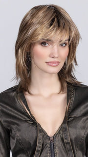 Model is wearing SAND MULTI ROOTED SAND MULTI ROOTED 14.24.12 | Medium Ash Blonde, Lightest Ash Blonde, and Lightest Brown Blend with Dark Shaded Roots