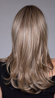 Model is wearing MARSEILLE by BELLETRESS in color MACADAMIA LATTE R | A combination of Medium and Light Brown, highlighted with Light Gold Blonde, and a mixture of Ash Blonde and Light Gold Blonde, Rooted with Medium and Light Brown