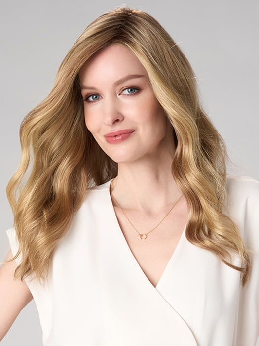 Model is wearing MAYA HAND TIED by ENVY in color SPARKLING CHAMPAGNE | Medium Brown roots with overall Strawberry Blonde base and soft Golden Blonde highlights