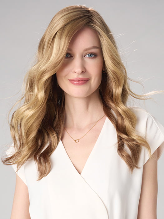 Model is wearing MAYA HAND TIED by ENVY in color SPARKLING CHAMPAGNE | Medium Brown roots with overall Strawberry Blonde base and soft Golden Blonde highlights
