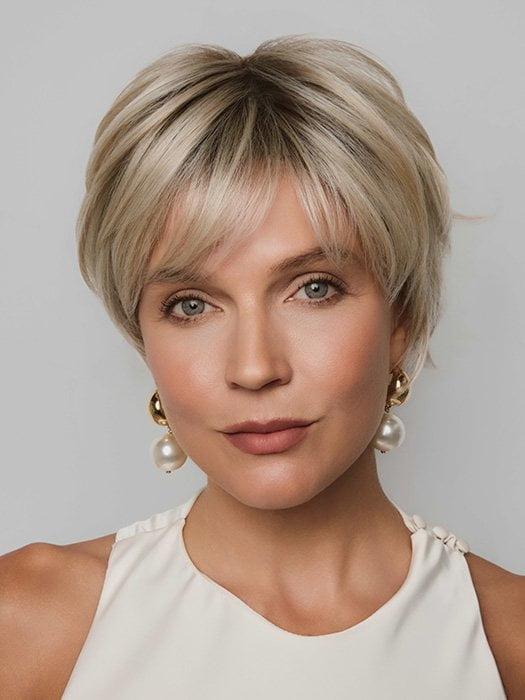 Model is wearing MIO by NORIKO in color SANDY CREAM BLOND R | A blend of beige brown, honey, and creamy blond with subtle roots.
