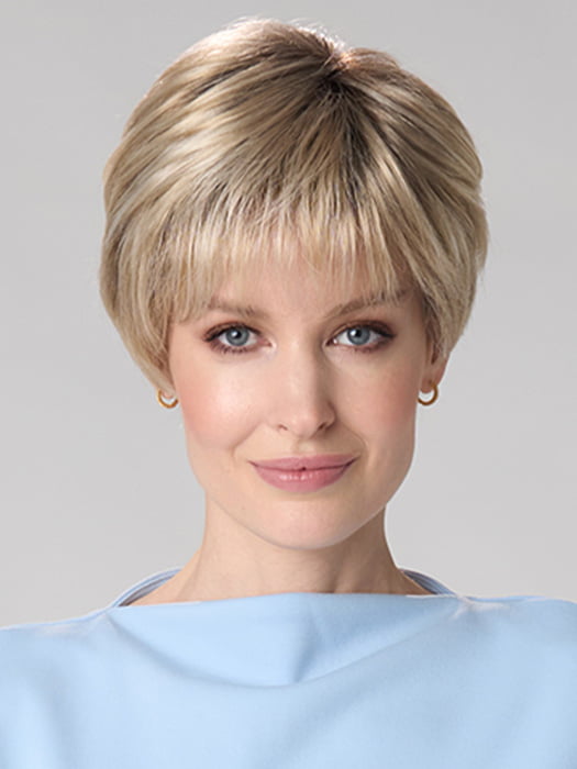 Model is wearing TIFFANY HAND TIED by ENVY in color SILKY BEIGE | Light Platinum Blonde with Dark Brown Roots