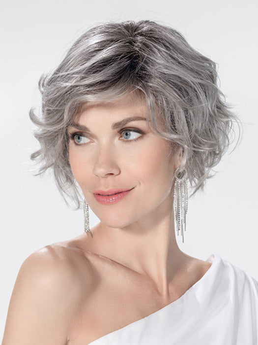 Model is wearing ROMANCE DELUXE by ELLEN WILLE in color METALLIC GREY ROOTED 60.51 | Pearl White, Darkest/Lightest Brown with Grey Blend with Shaded Roots